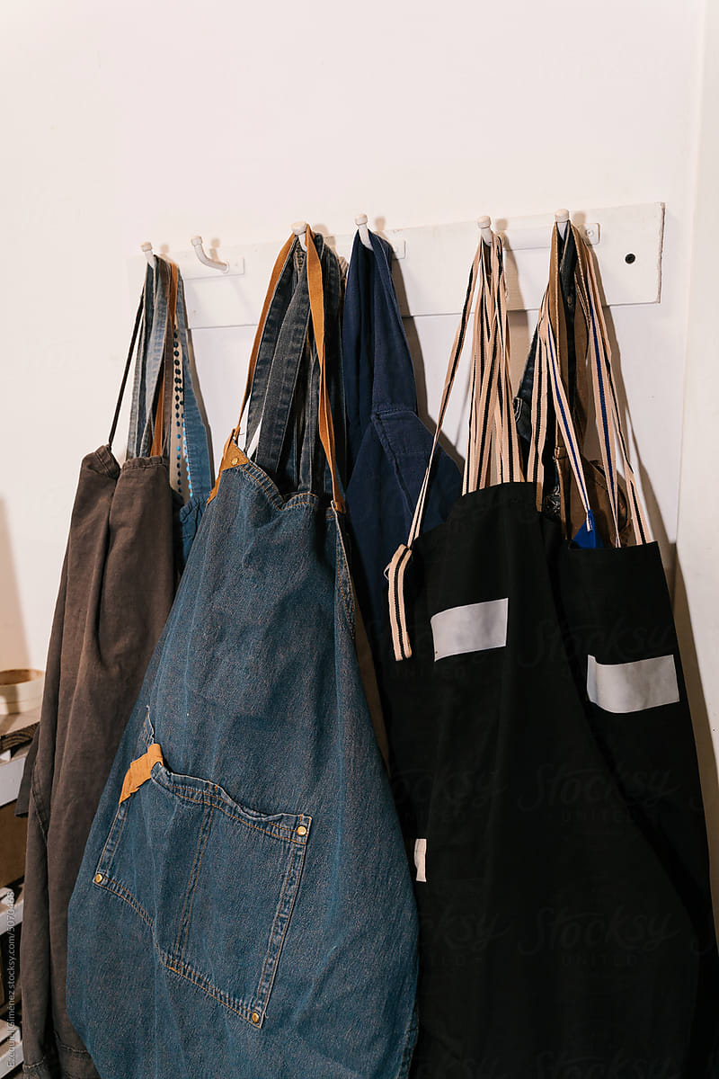 Denim aprons hanging on wall in workshop