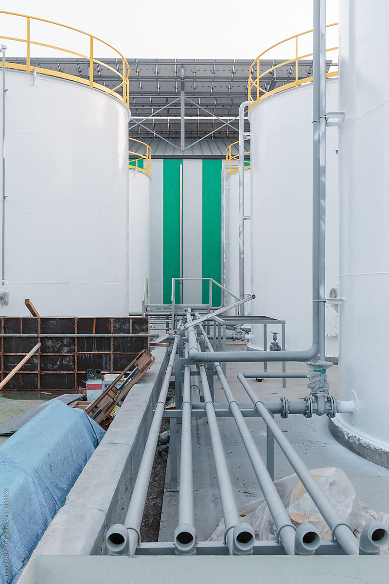 A white storage tank in a factory under construction.
