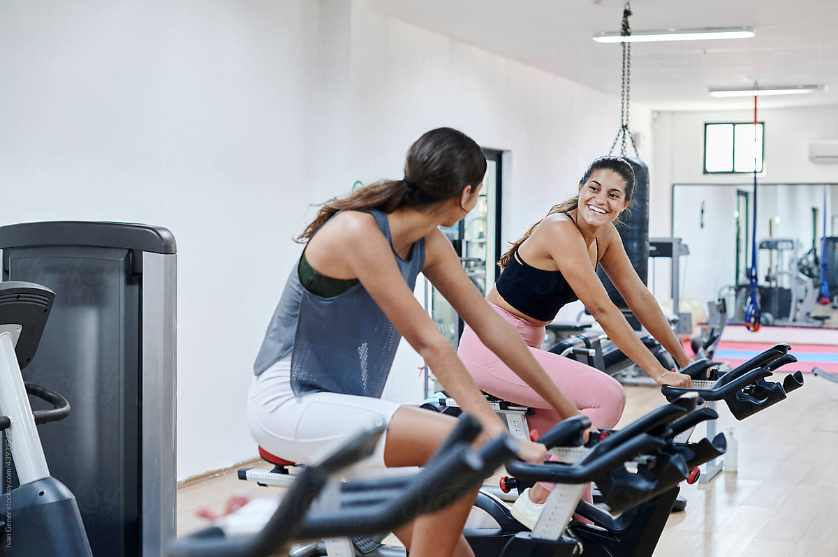 Young women riding stationary bikes