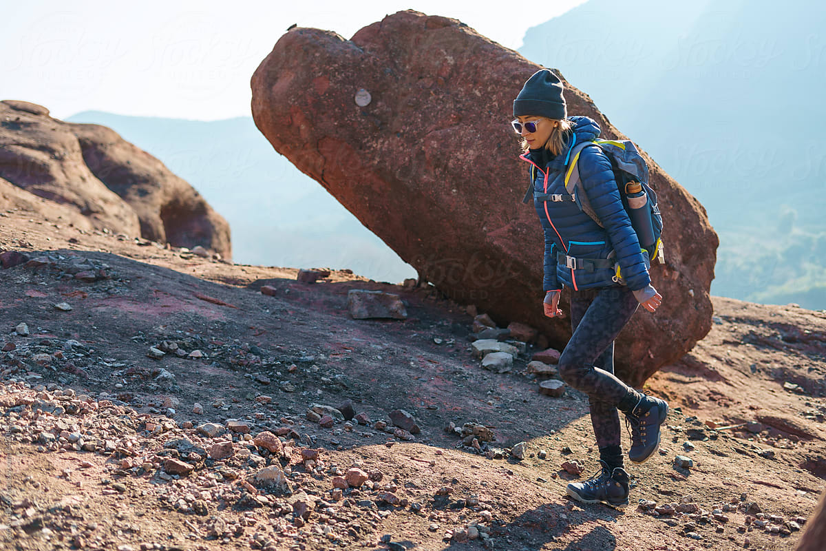 Female hiker walking on rocky mountain slope