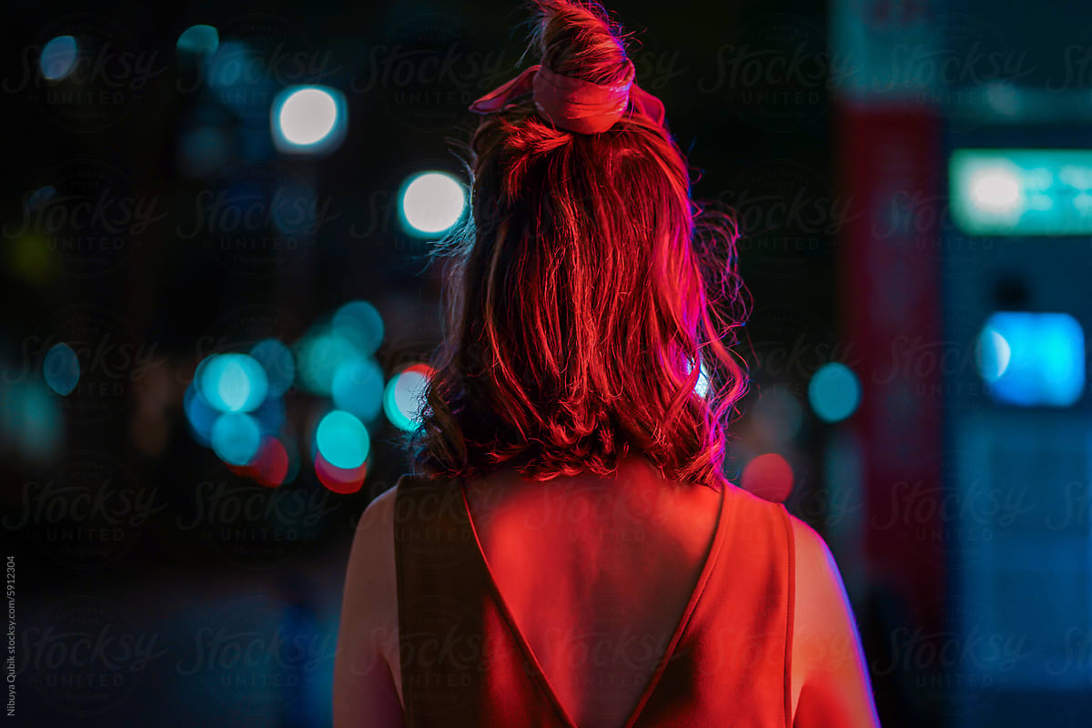 portrait of young woman with her back to camera at night