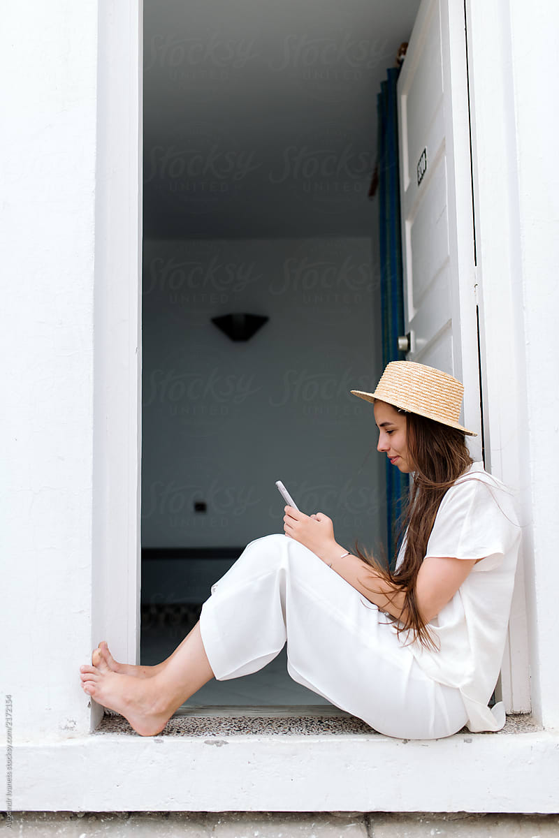 Barefoot Female Browsing Smartphone On Doorstep By Stocksy Contributor Alexandr Ivanets