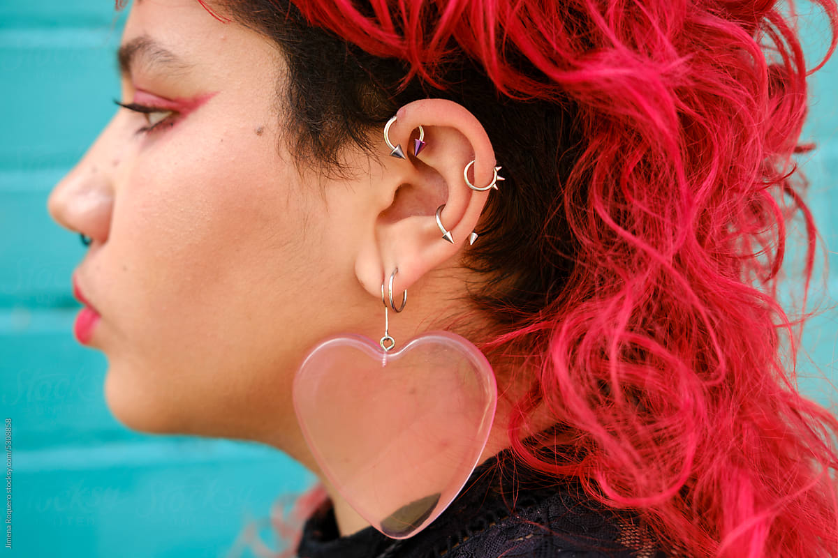 Profile of non-binary person with pierced ear and red hair