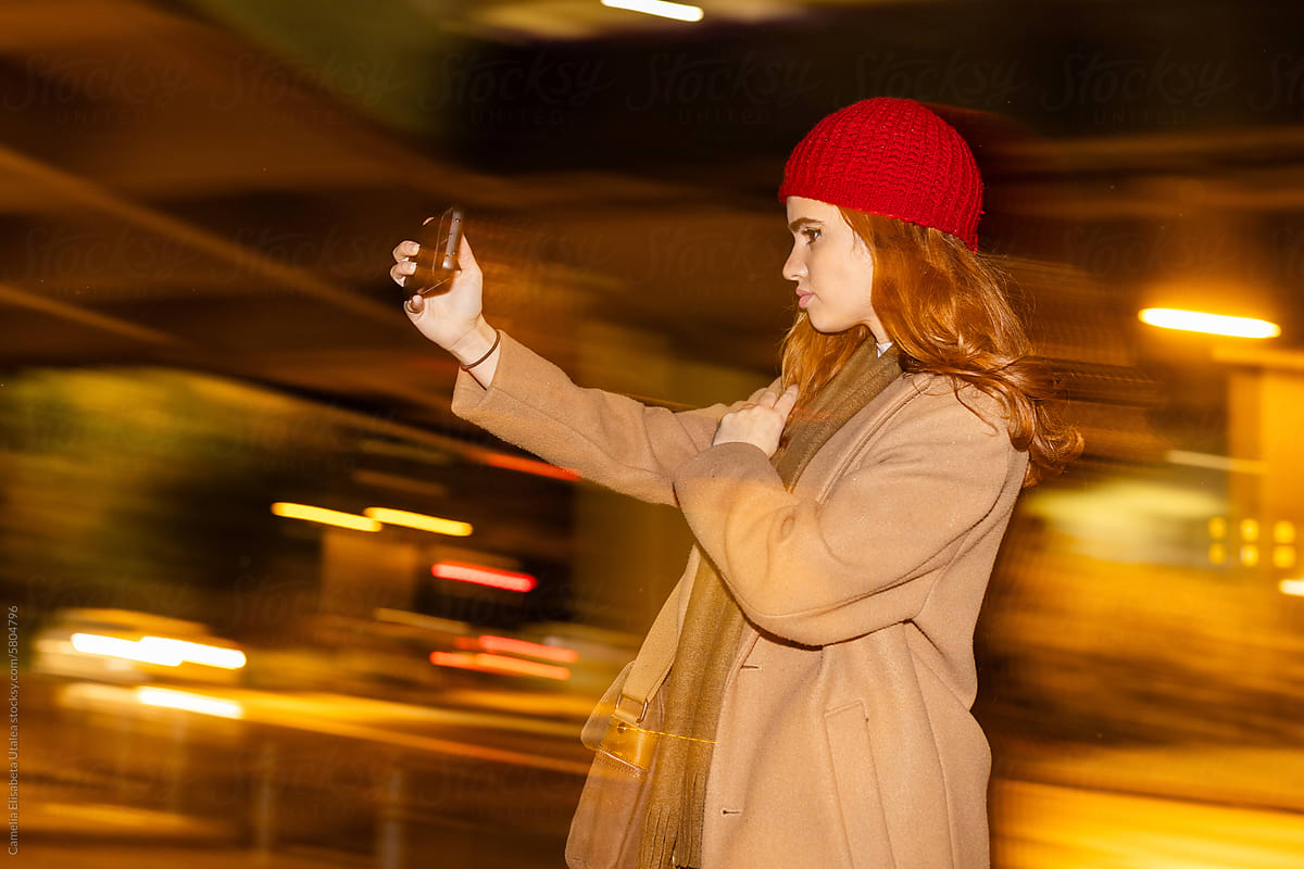 a girl taking a selfie on the street
