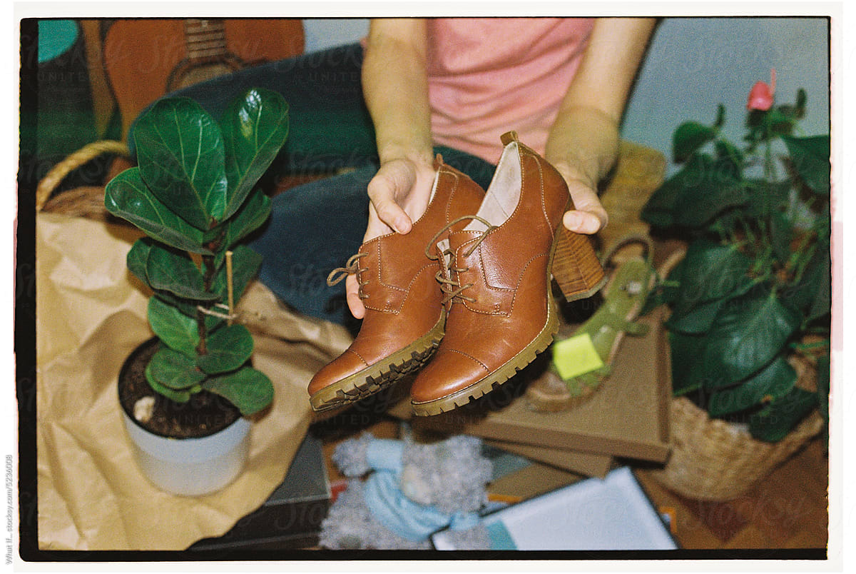 Old design shoes in the hands of a woman in the market.