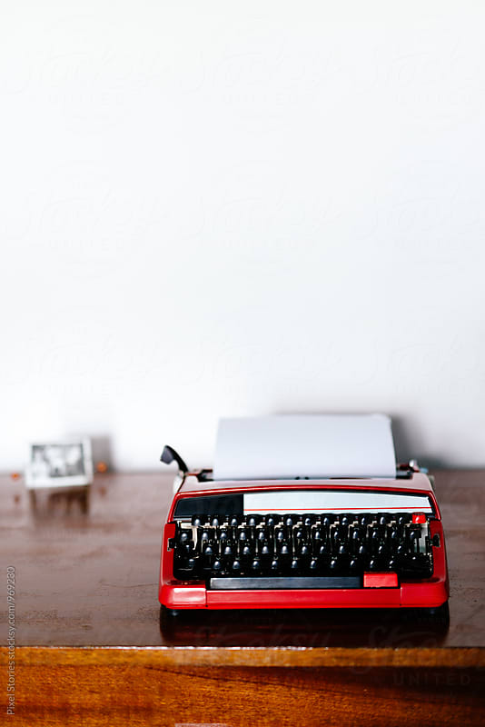 Vintage red typewriter on wooden desk