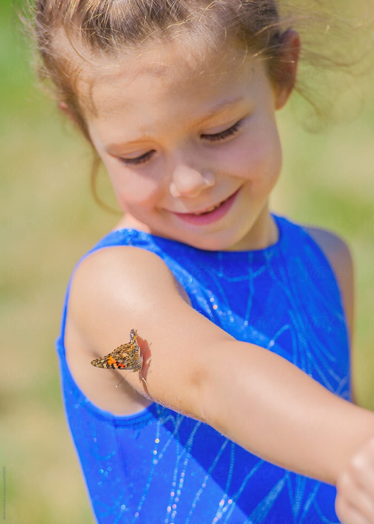 Childhood Moment: Little Girl Smiling at Butterfly on Shoulder