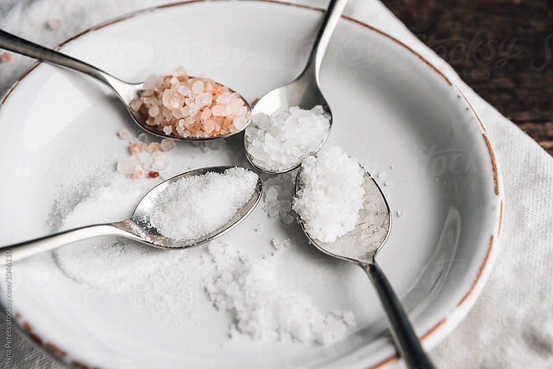 Food: Different sorts of salt on spoons, Himalayan (pink), sea salt, fleur de sel, stone salt