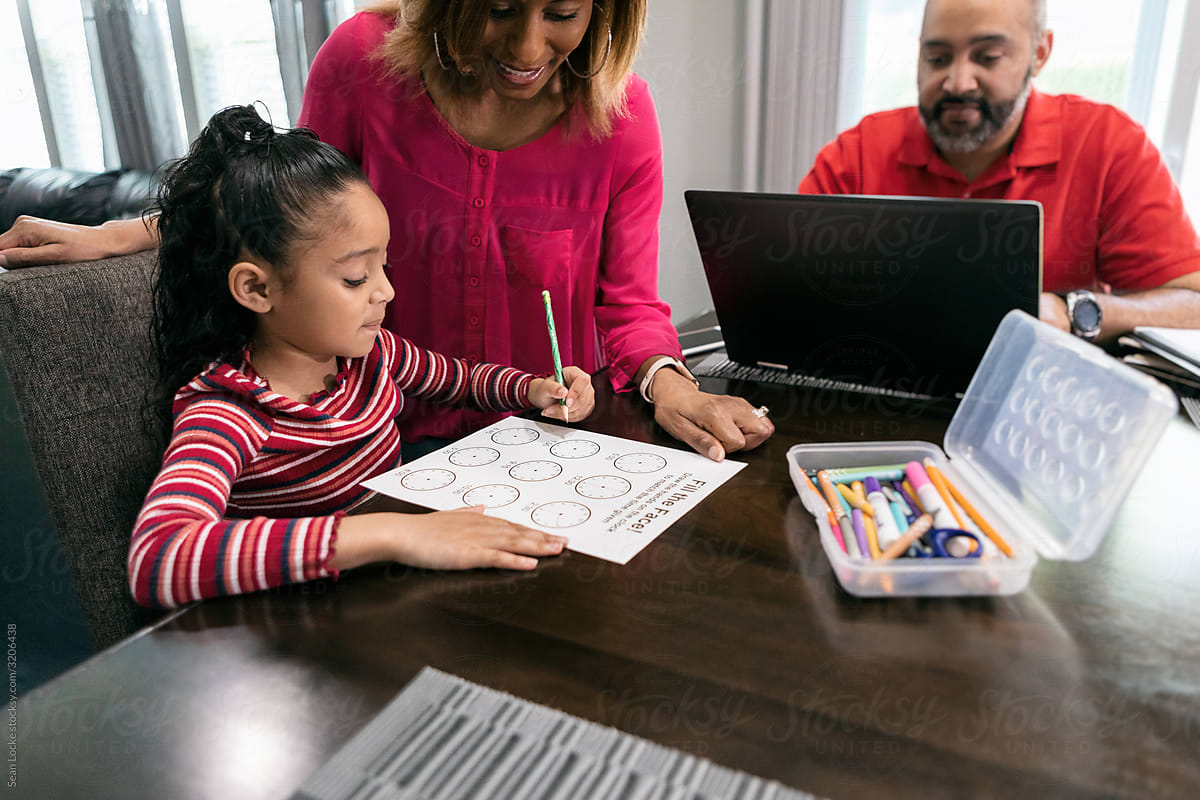 Home: Mother Teaching Daughter How To Tell Time On Homework