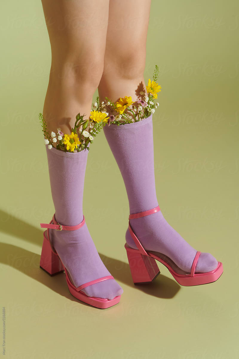 Legs of beautiful young woman with flowers in socks
