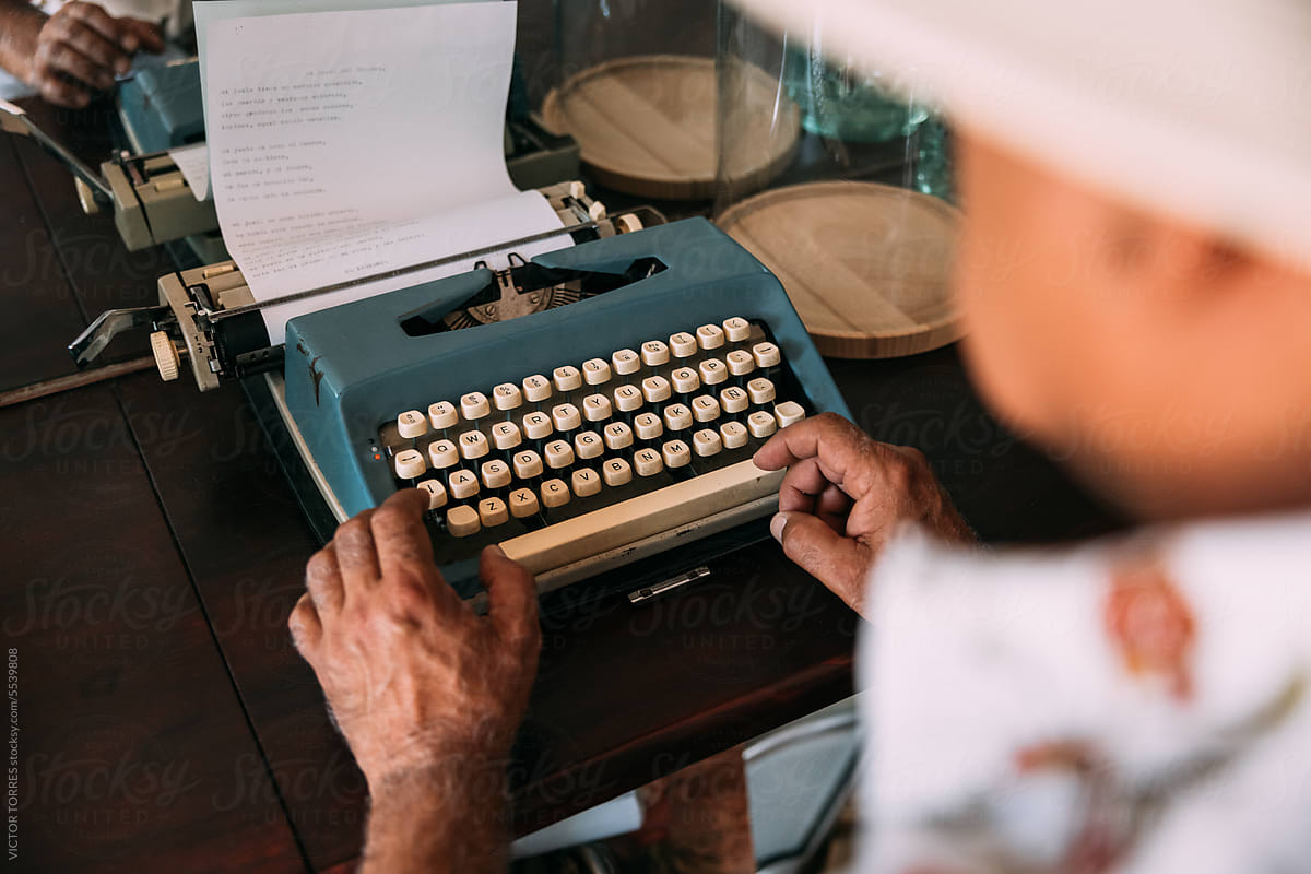 Crop man typing poem on vintage typewriter