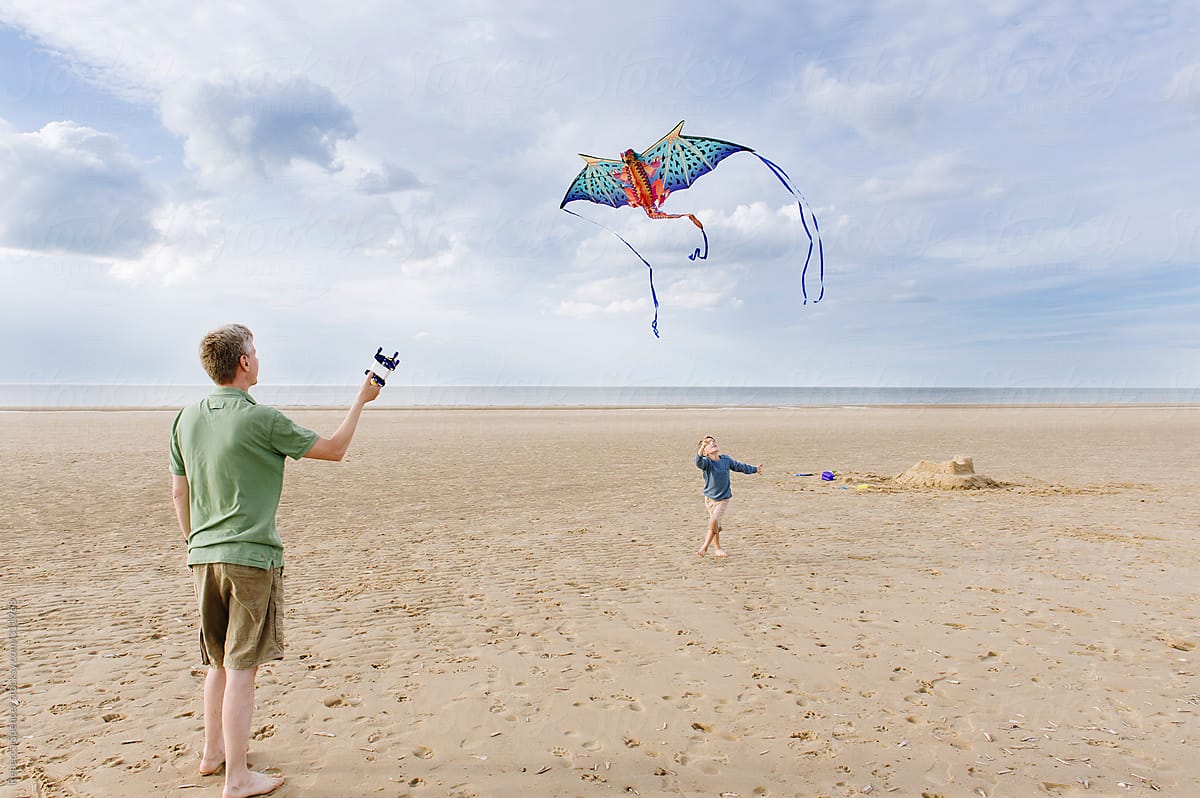 Boy flying dragon kite on the beach