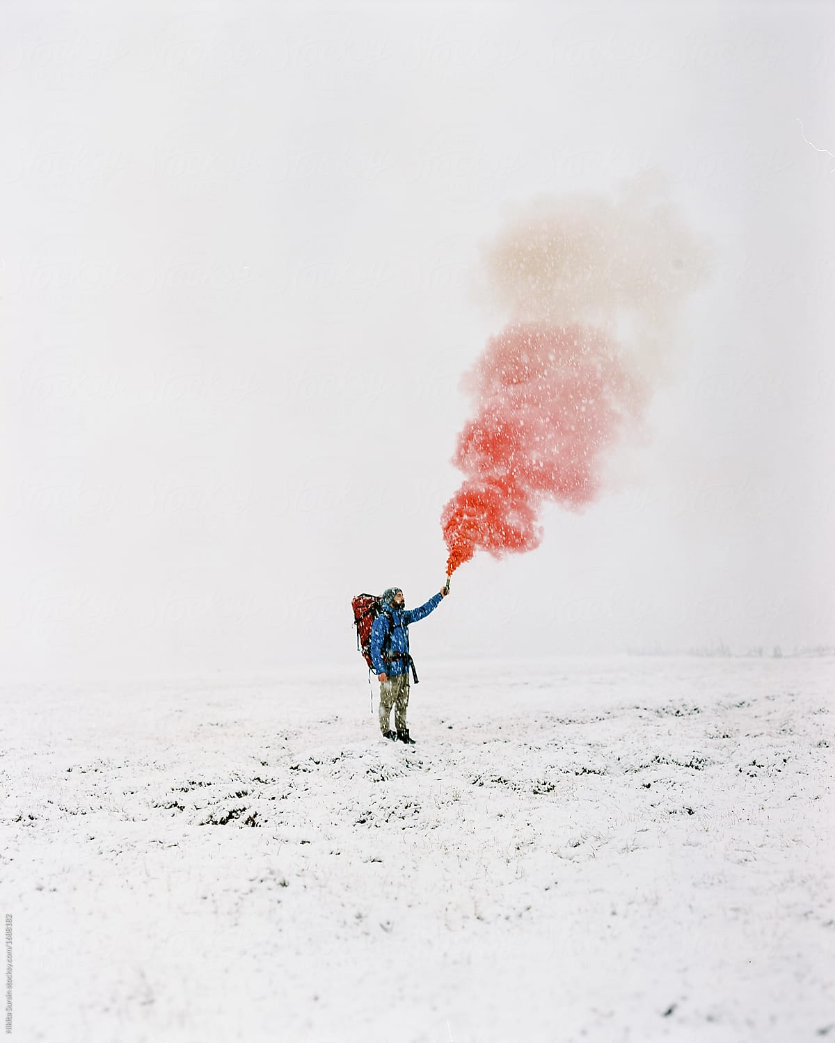 Hiker holding in hand colorful smoke bomb