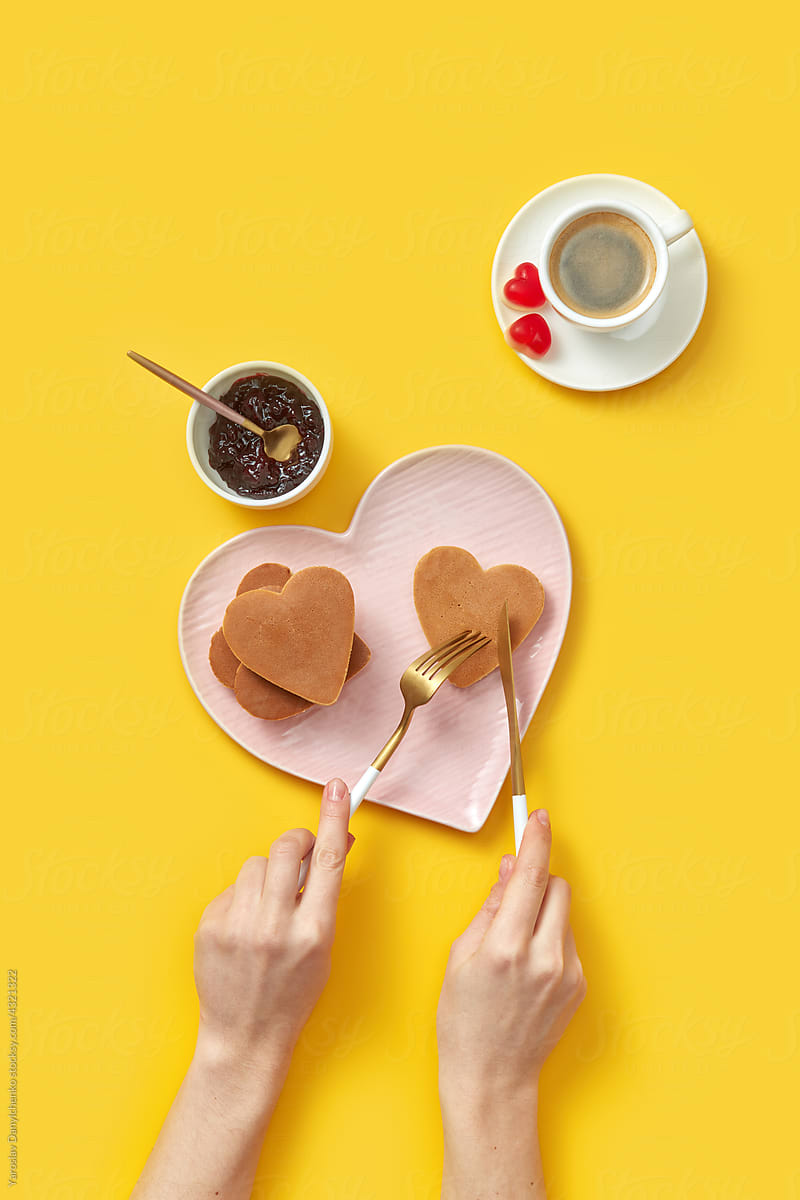 Woman eating heart shaped pancakes