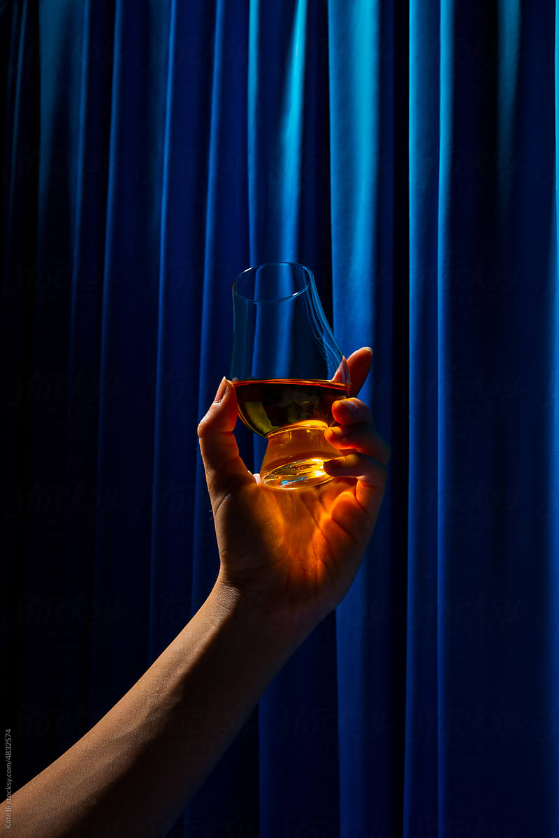 Hand rasing a glass with Whisky