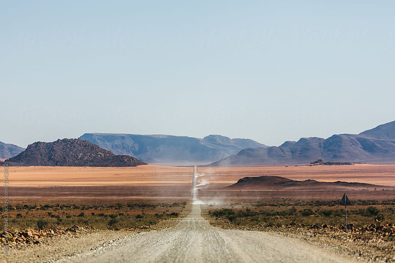 Long straight empty desert road leading into the horizon