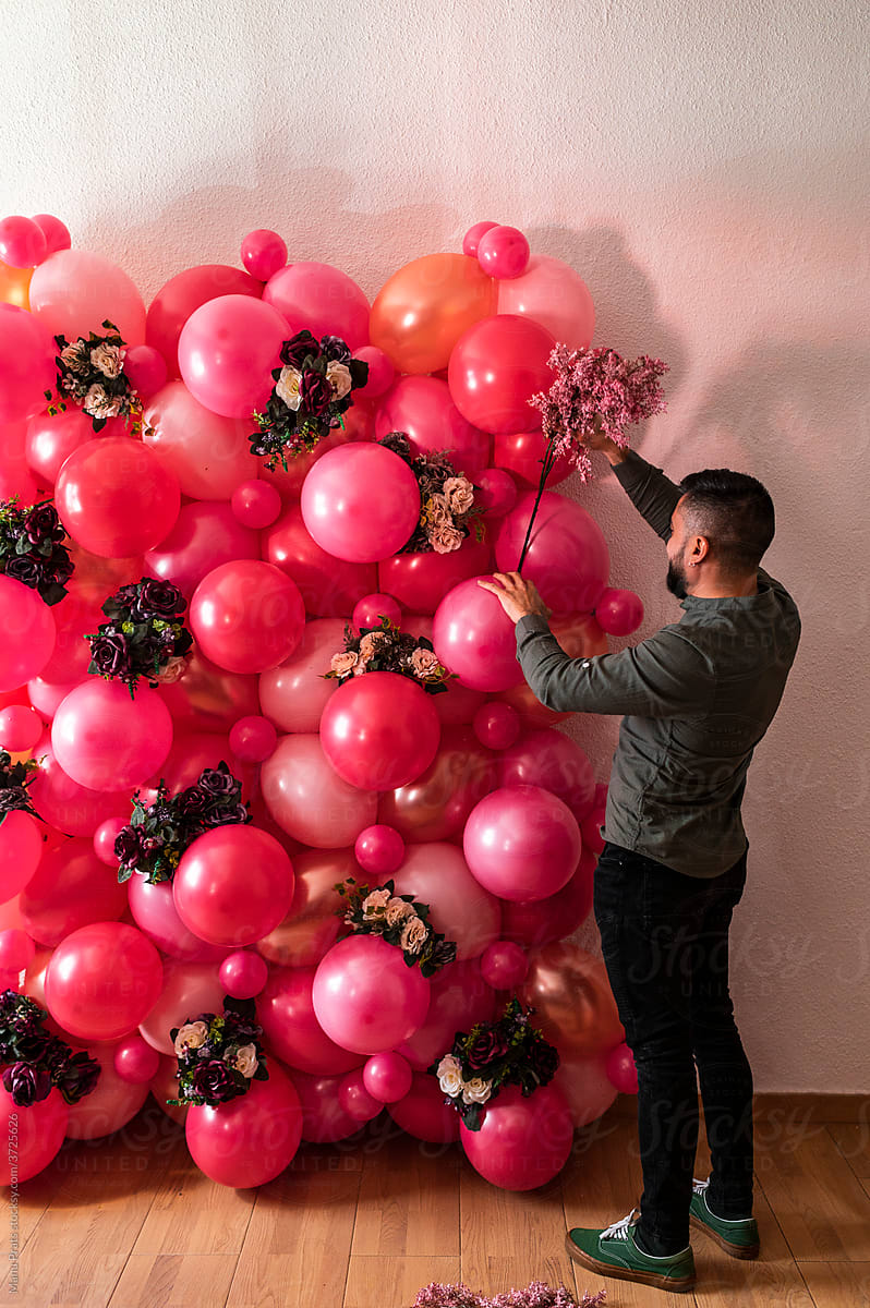 Hispanic male creating decoration from air balloons