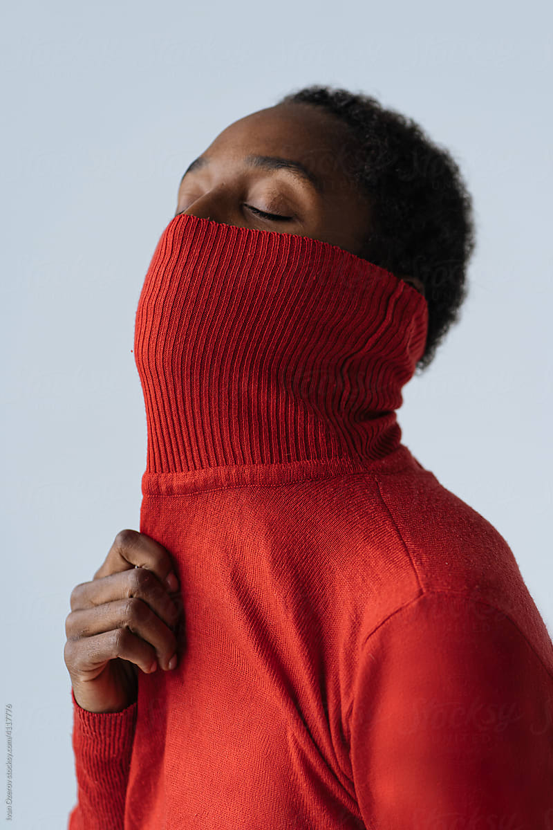 Black woman covering mouth with turtleneck