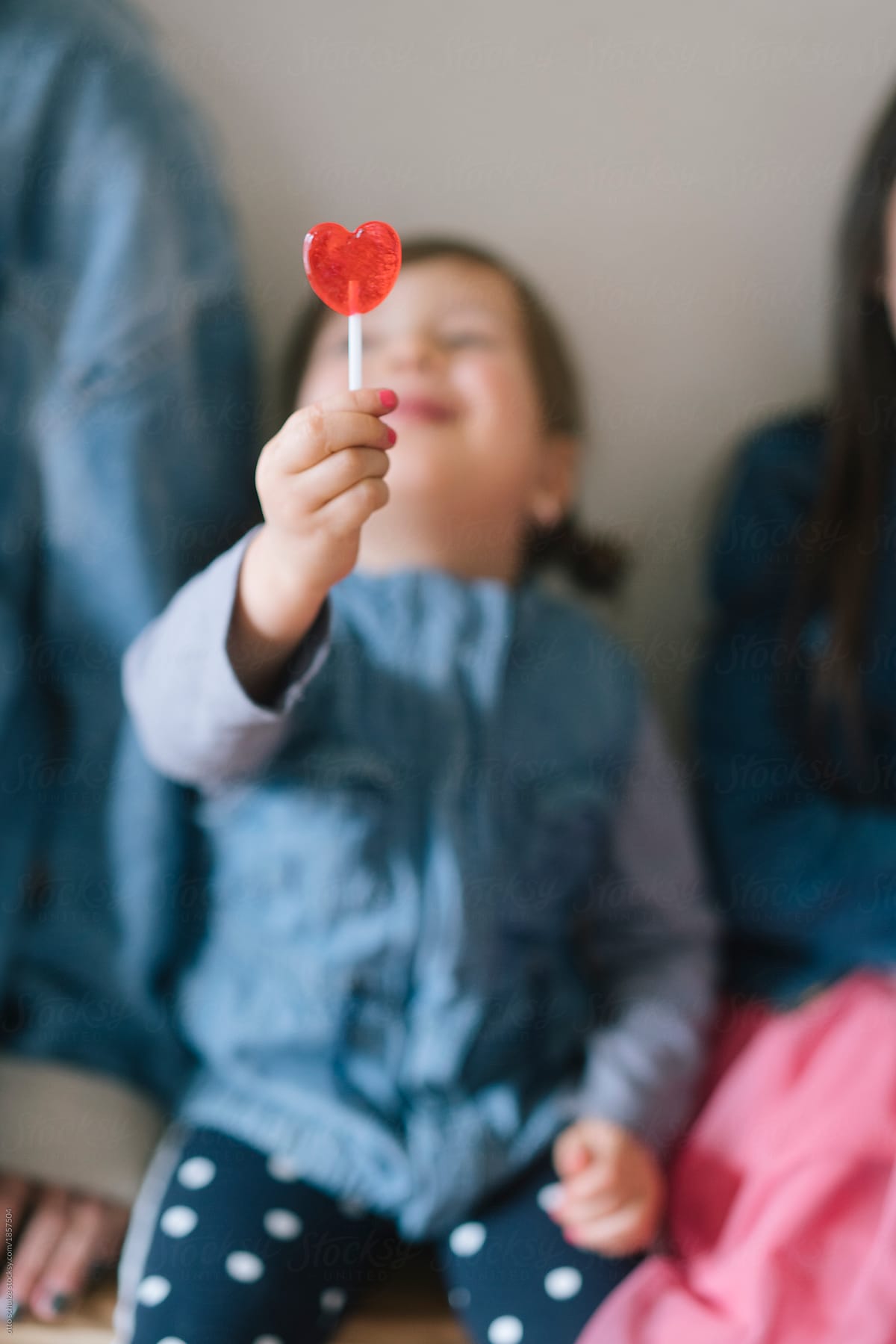 Girl holding heart lollipop