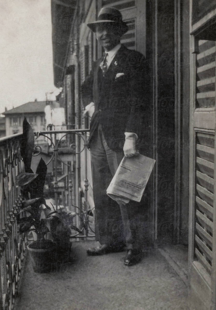 1936. Man holding a newspaper on the balcony