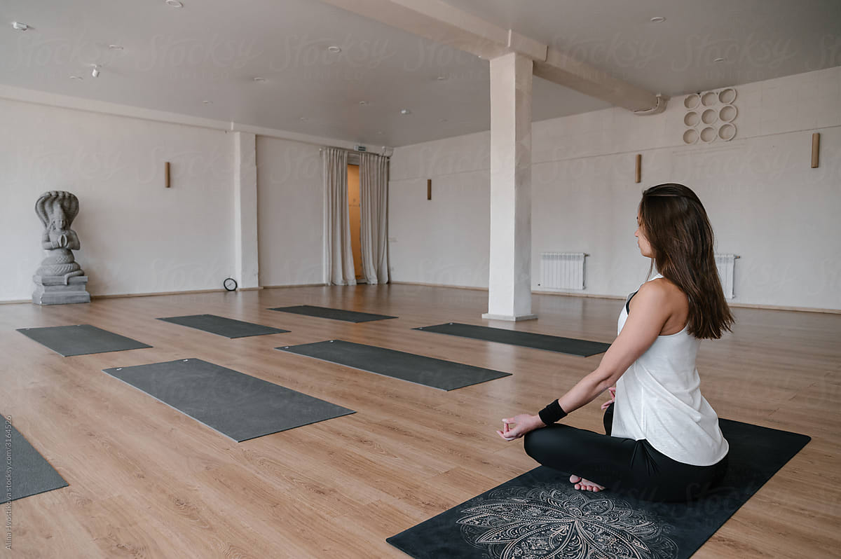 Yoga trainer meditating in empty studio