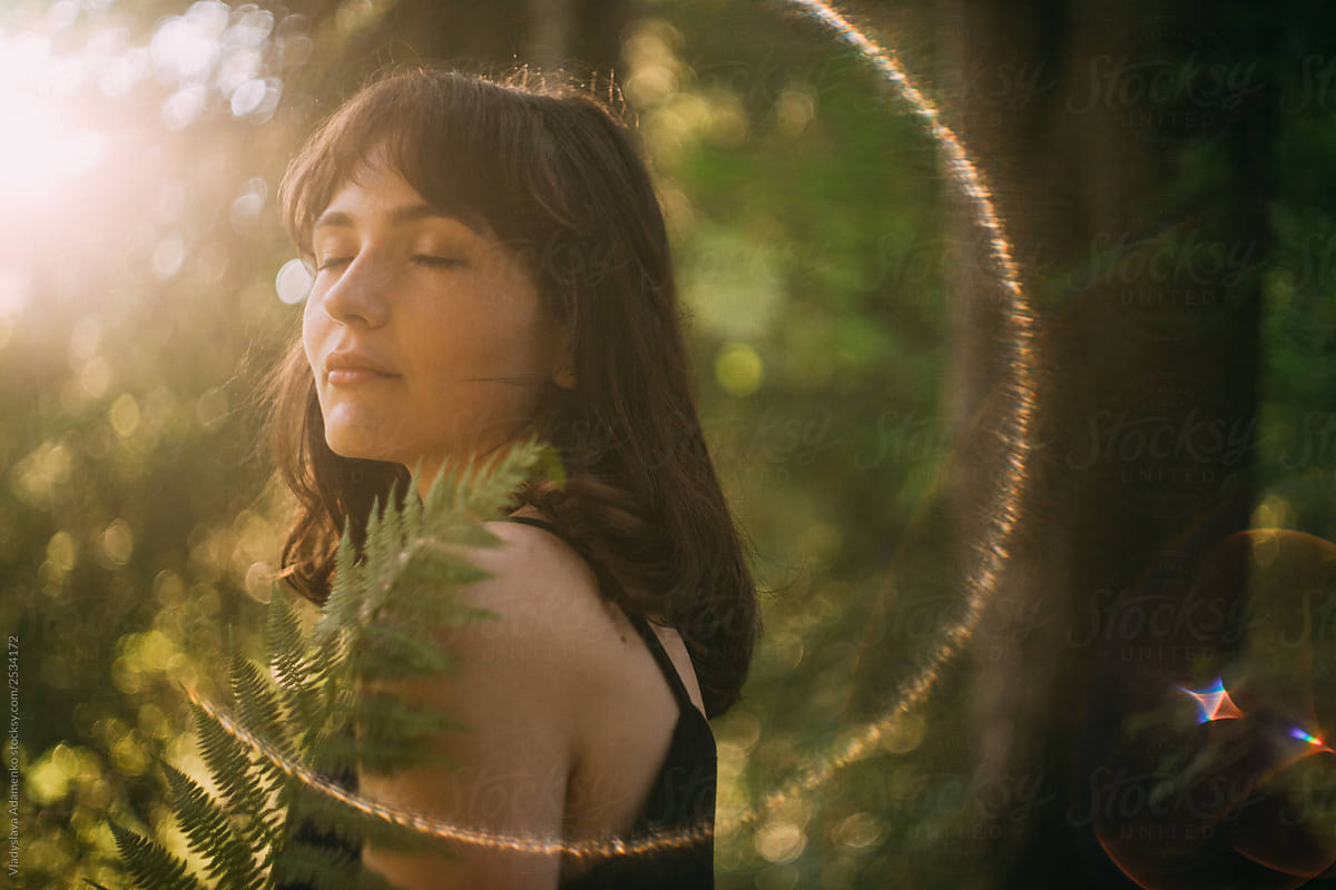 Portrait Of Young Woman With Eyes Closed And Fern In Her Hands Standing In The Forest Cathing 