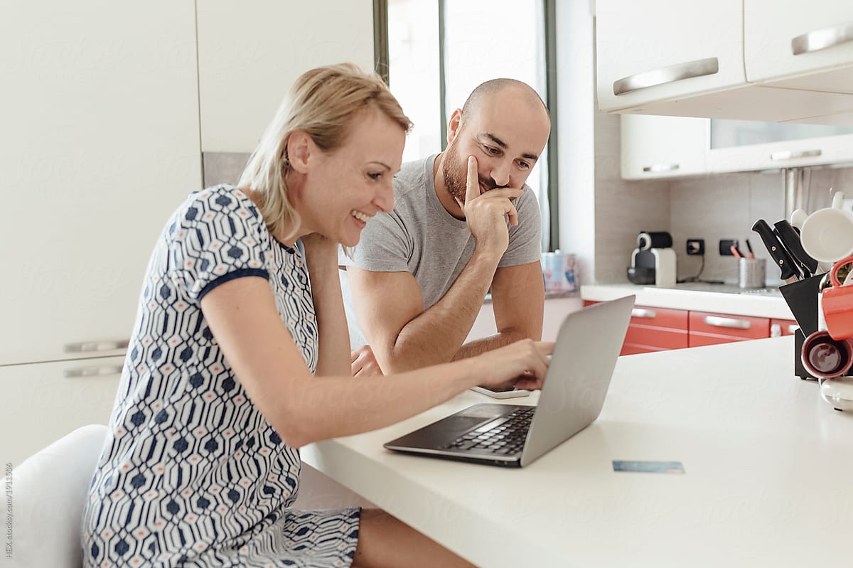 Adult Couple Using A Laptop From A Kitchen During The Morning Breakfast By Stocksy Contributor 3111