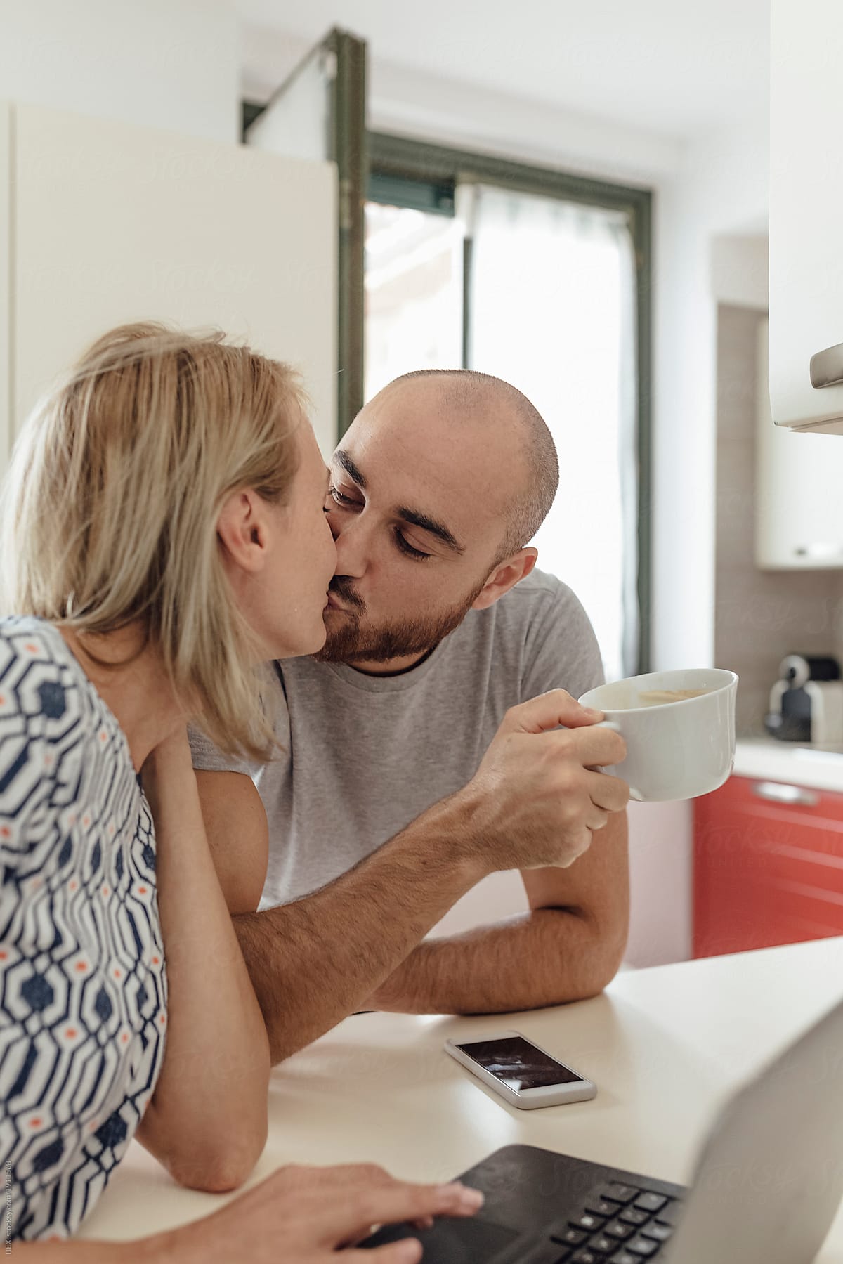 Adult Couple Using a Laptop From a Kitchen during the Morning Breakfast