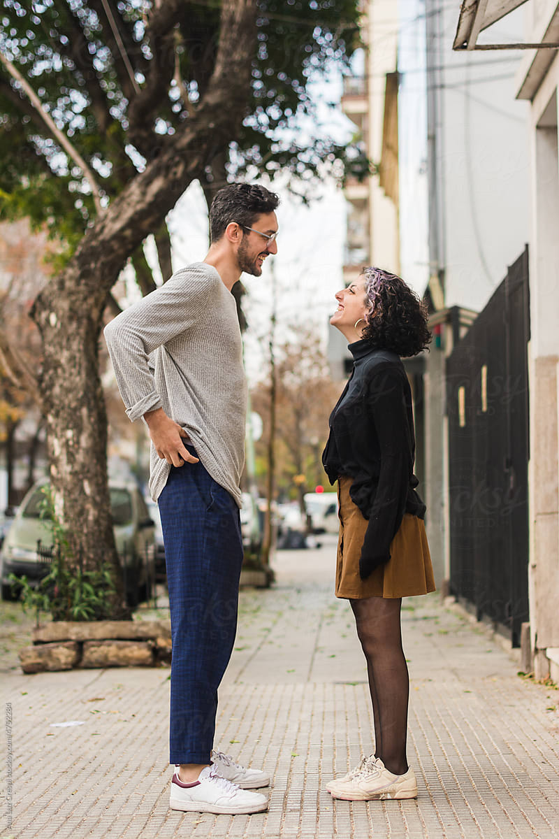 Couple Talking In The Street - Height Difference by Stocksy