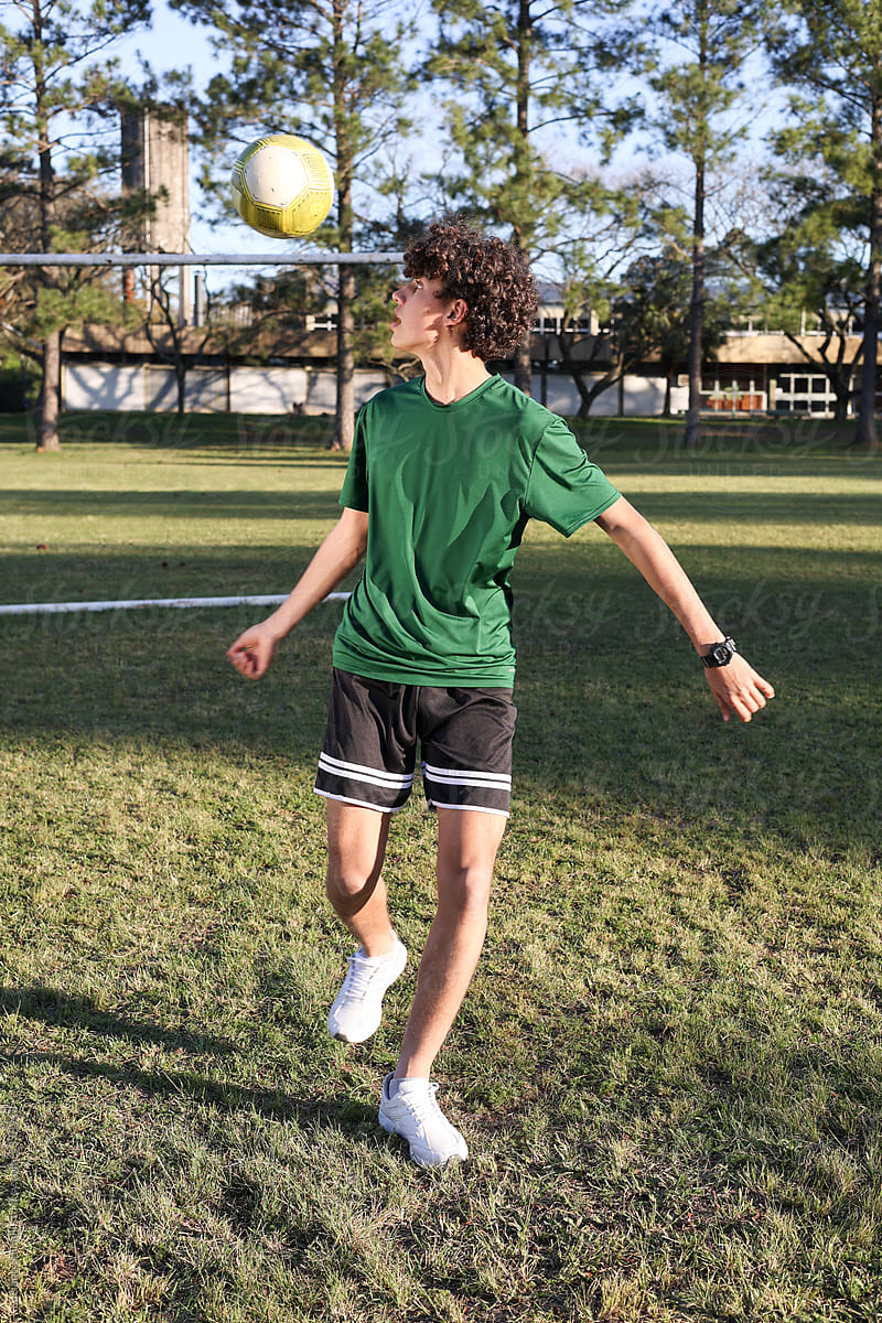 Young man doing soccer tricks with a the ball on his back