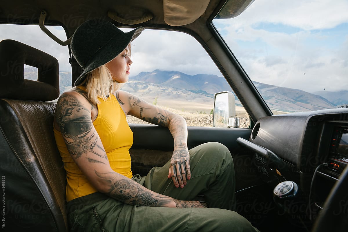 young tattooed blonde woman sitting in the car