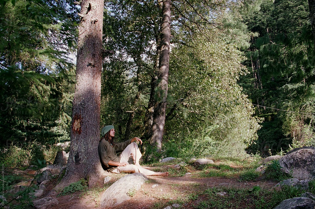 Dreadlock Hippie Sitting in Forest