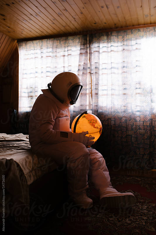 Astronaut with globe on bed