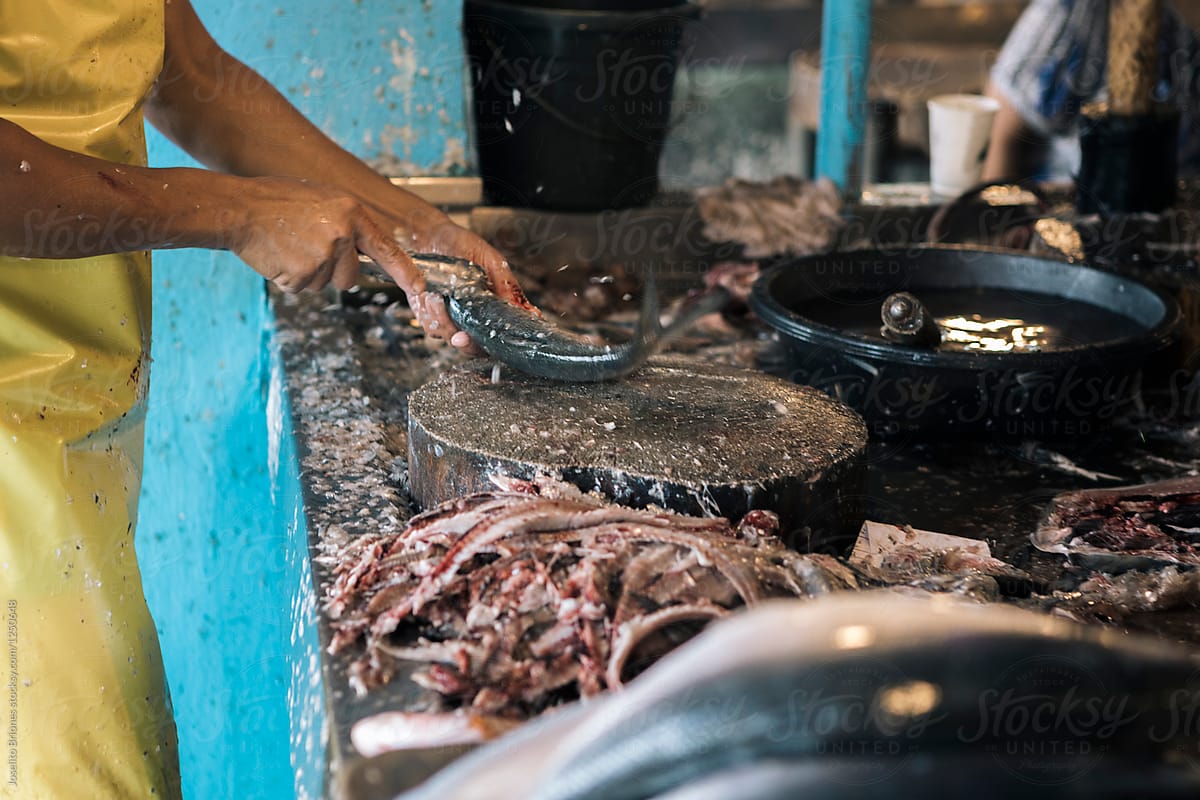 Fishmonger Deboning and Descaling Milkfish or Bangus in a Market in the Philippines