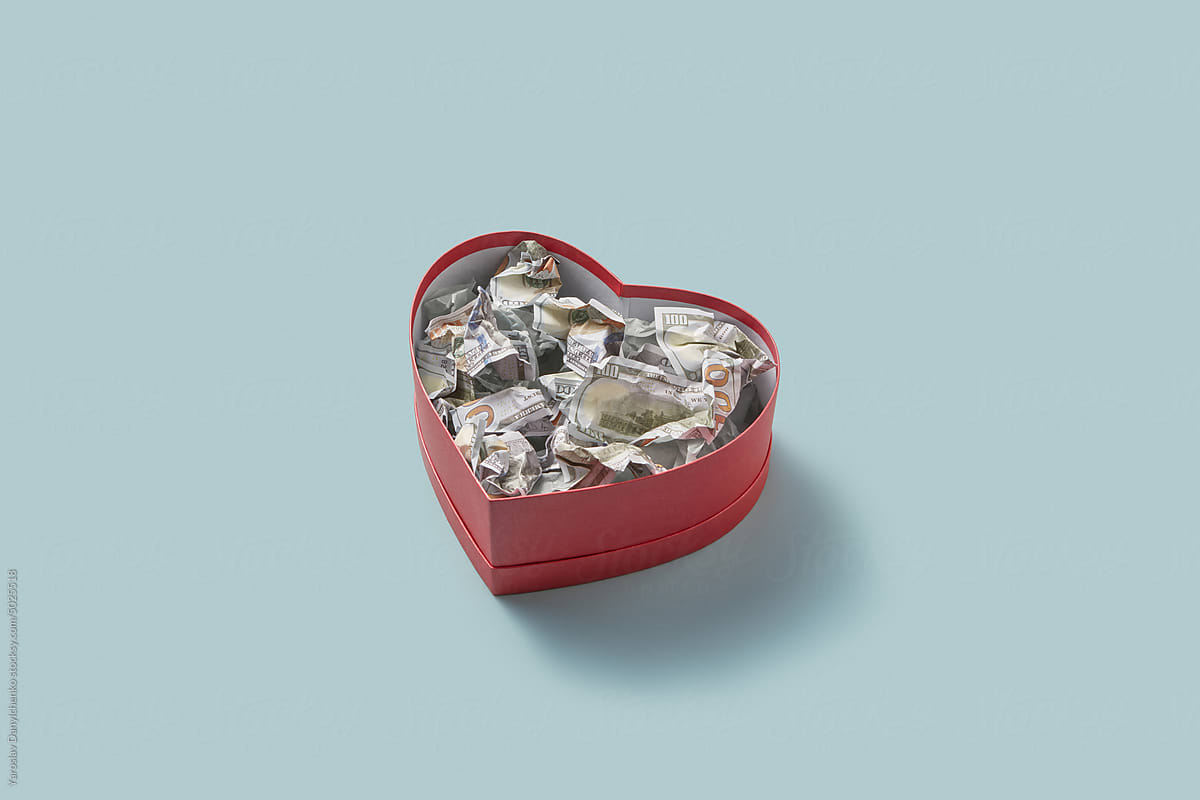Heart-shaped box with crumpled 100 dollars.
