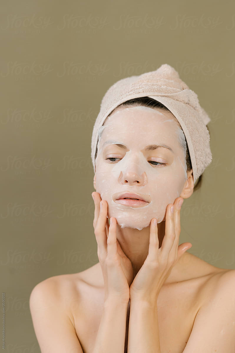 Woman applying sheet facial mask