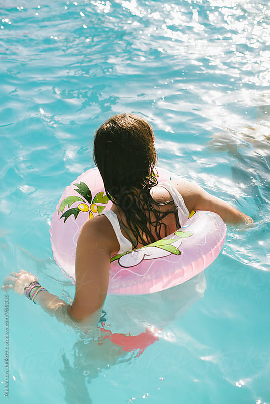 Girl with Inflatable Tube Swimming in the Pool
