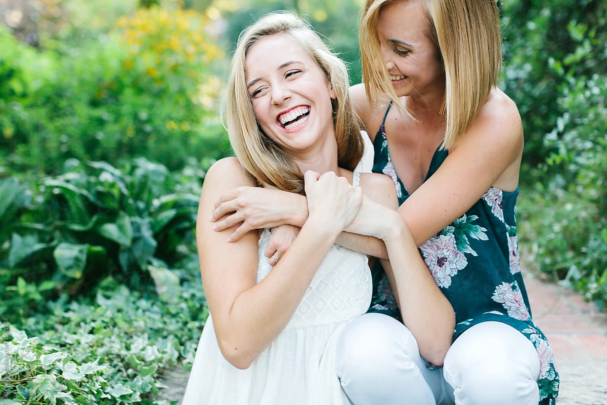 Two young girls laughing and hugging