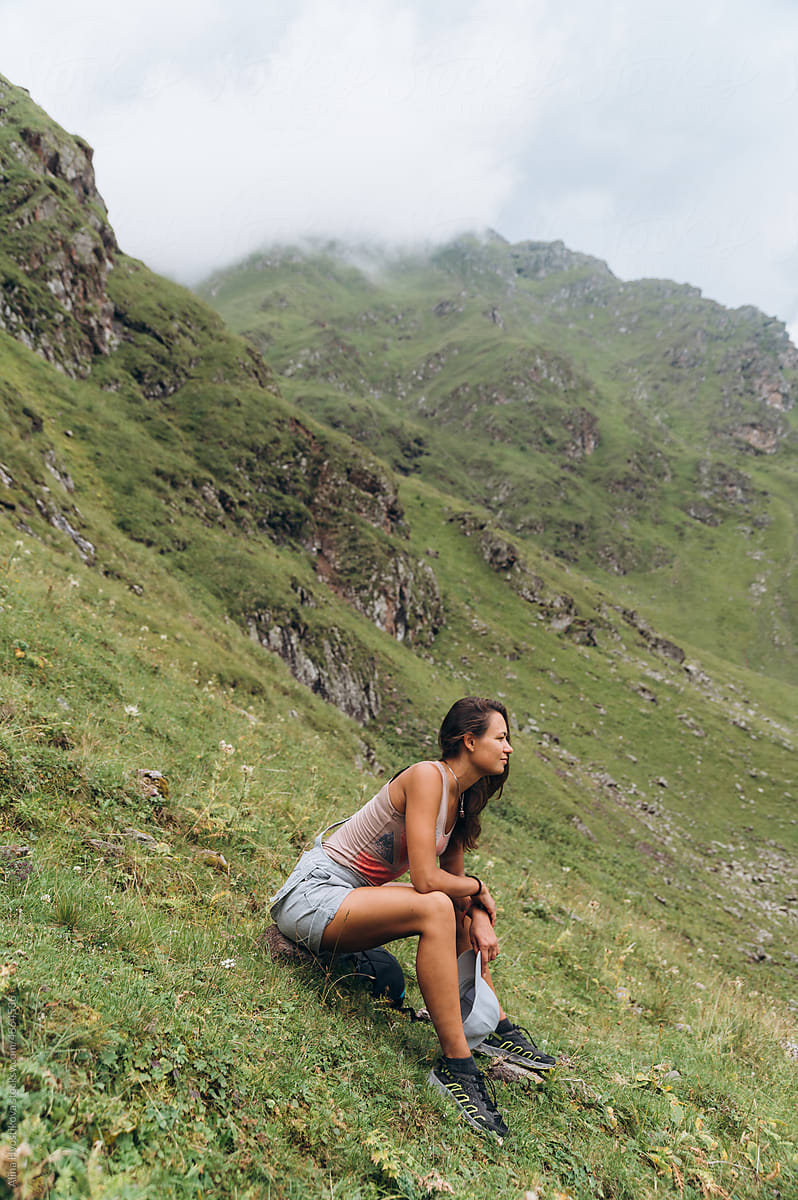 Young lady recreating on mountain slope during trekking