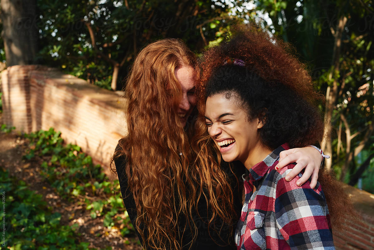 Multiethnic Girlfriends Hugging And Laughing In Park By Stocksy Contributor Guille Faingold 