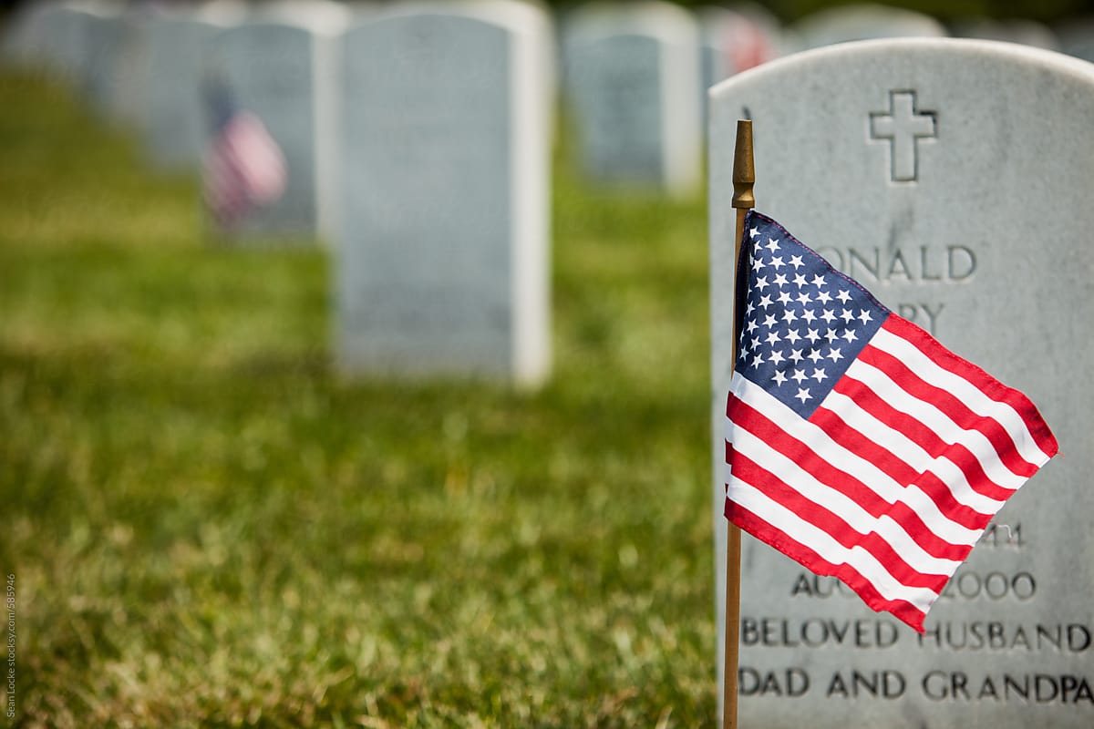Memorial: American Flag Blows In The Wind Near Headstone