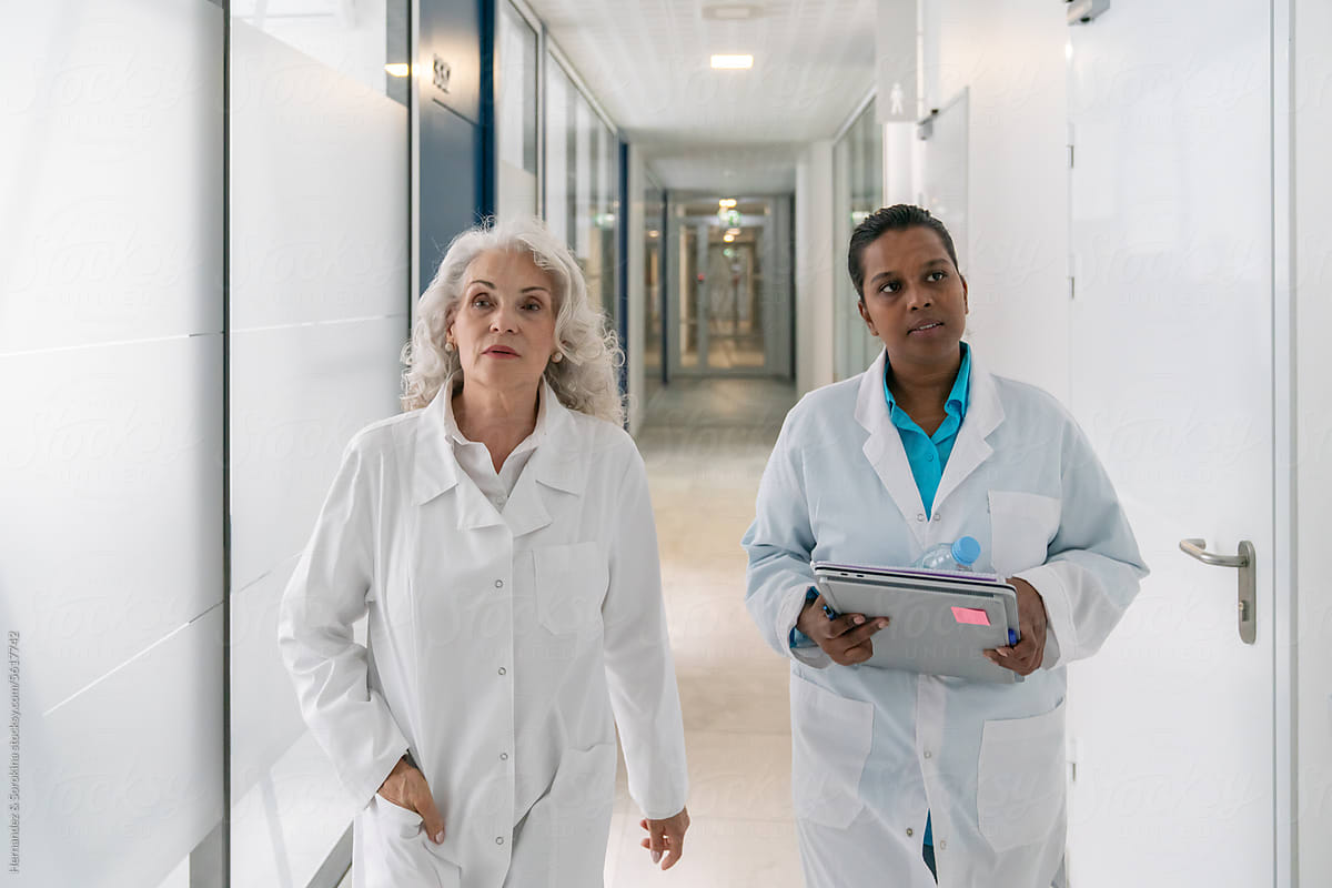 Doctors Walking At Corridor In Modern Science Centre