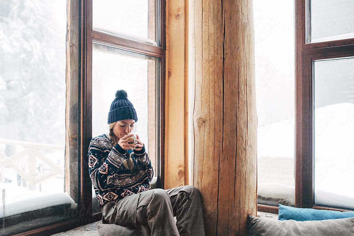 Woman Enjoying Tea in Log Cabin
