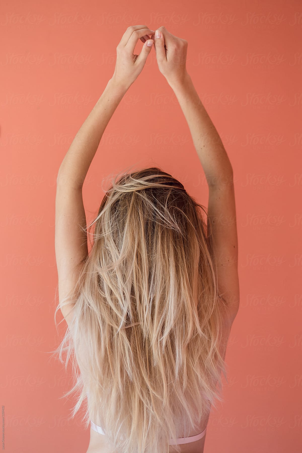 Anonymous blonde woman with arms up