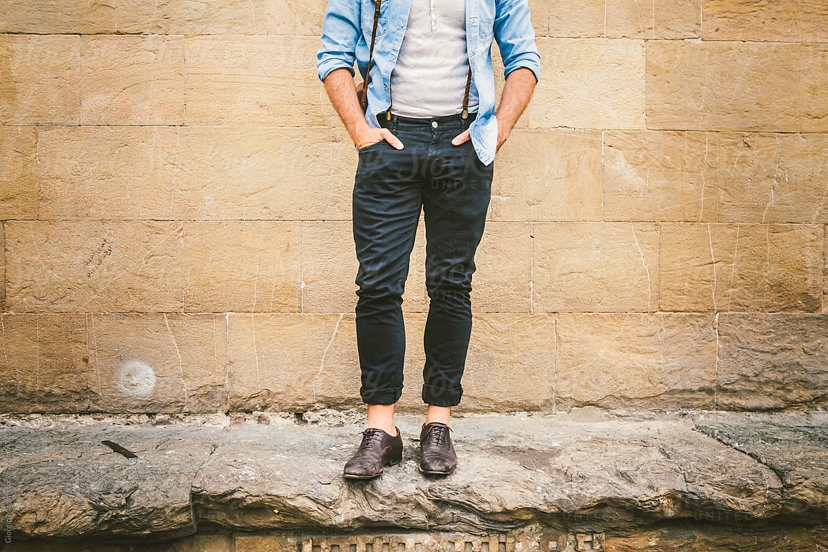 Fashionable Man Leaning over an Old Stone Wall