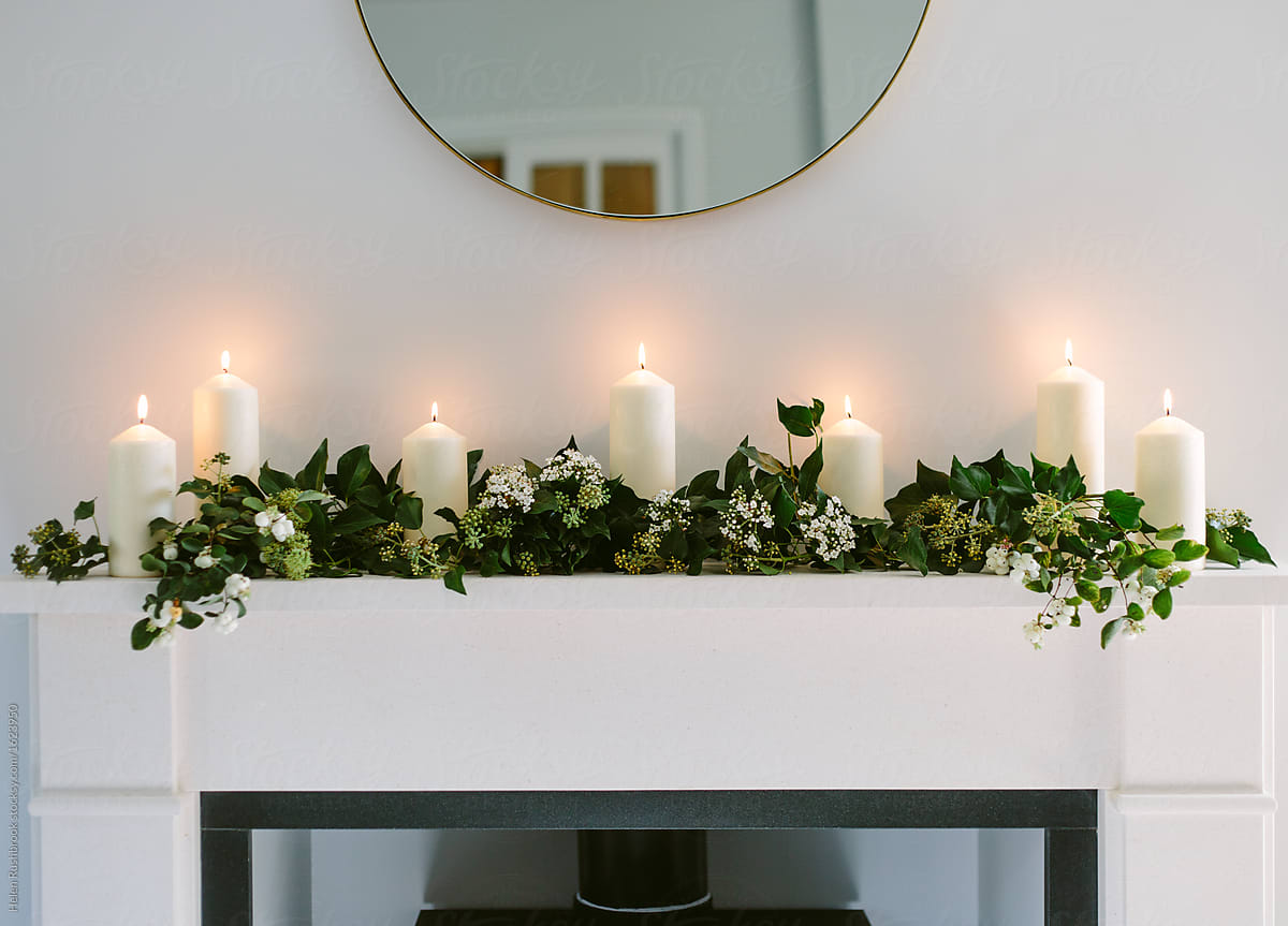 Pillar candles and foliage on a mantlepiece