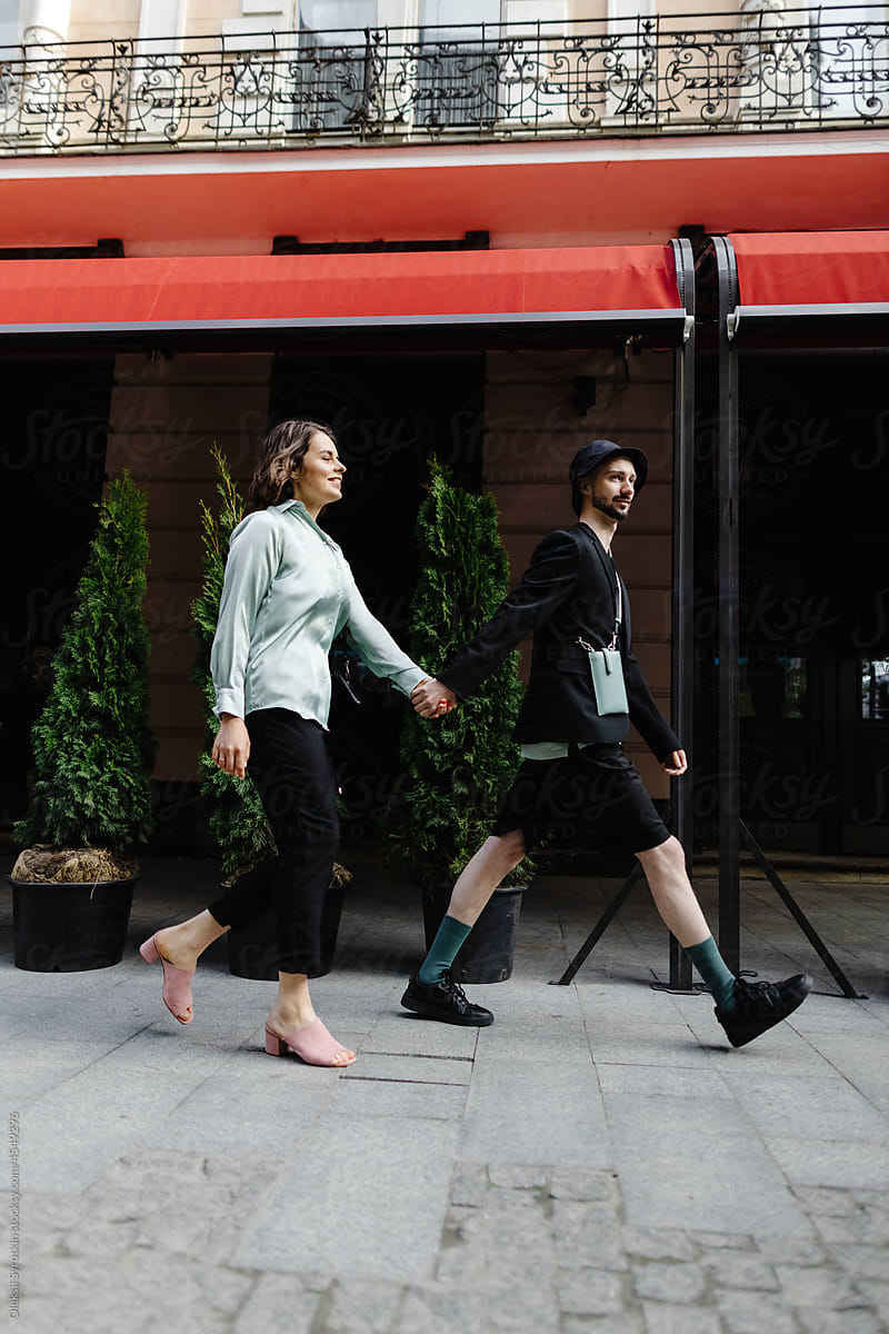 Couple in apparel with similar color walking on city road during date