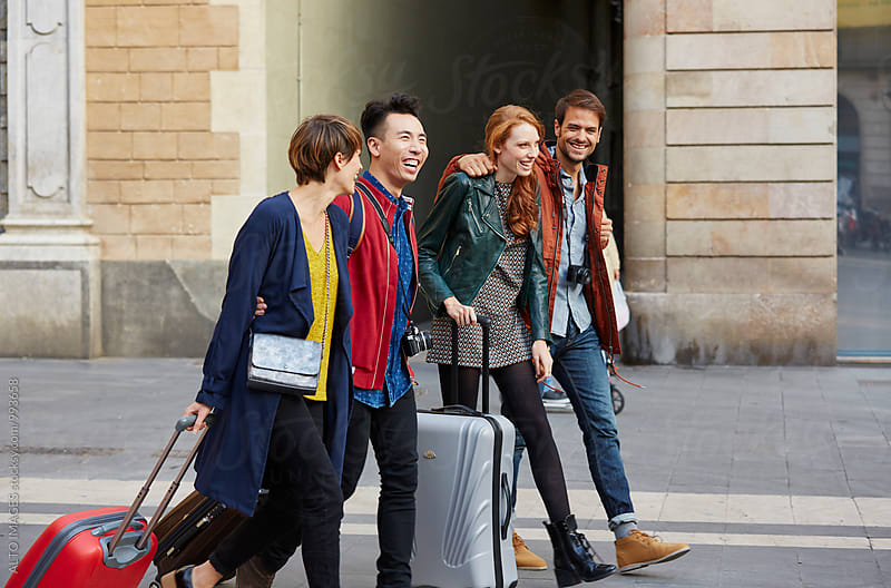 Happy Friends With Luggage Walking In City