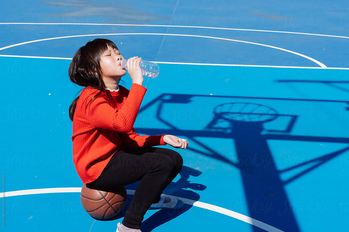 little girl drink water and rest  on the court