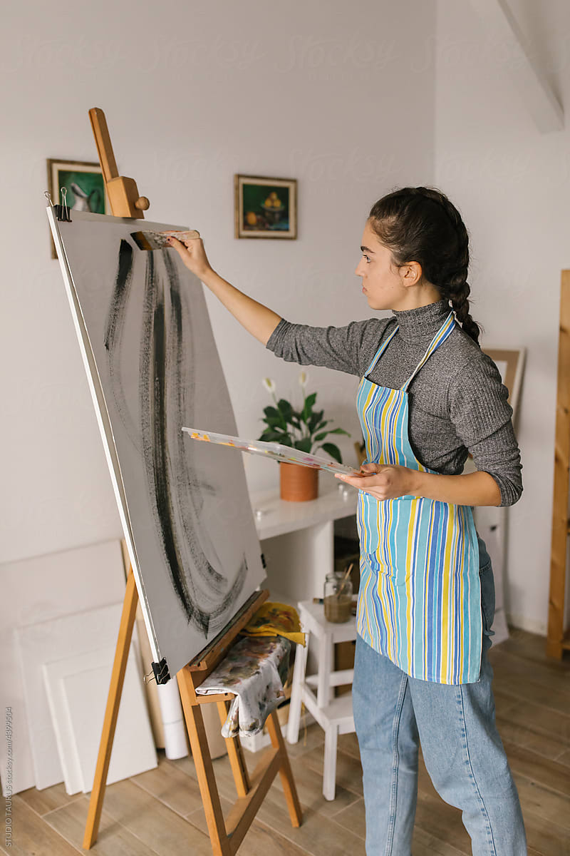 Female artist painting on canvas in the studio